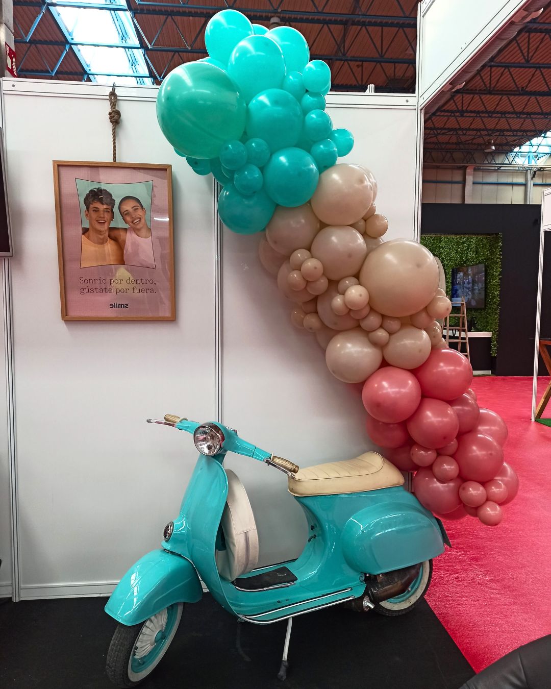 Guirnalda de globos color turquesa, beige y tierra en diagonal sobre una moto